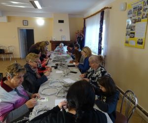 Osoby wykonują ozdoby wielkanocne podczas warsztatów