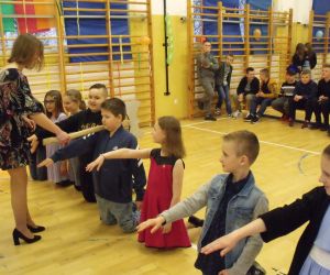 Uczennica klasy ósmej dokonuje aktu pasowania czwartoklasistów na uczniów klas starszych