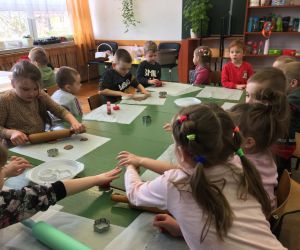 Dzieci wycinają foremkami ciasteczka