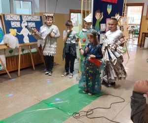 Uczniowie w strojach ekologicznych wykonanych z surowców wtórnych mówią wiersze i śpiewają piosenki