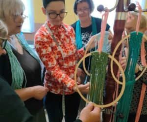 Panie zaplatają makramy.