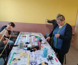 Kobiety zaplatają makramę.