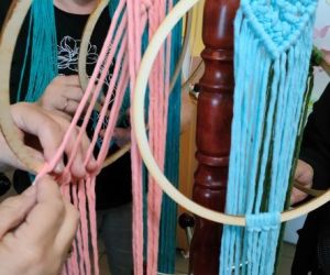 Kobiety zaplatają makramę.