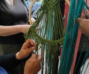 Kobiety zaplatają makramę.