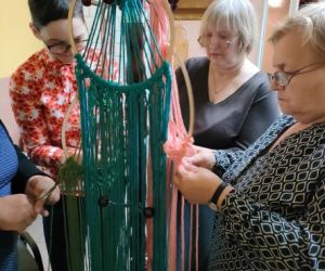 Kobiety zaplatają makramę.