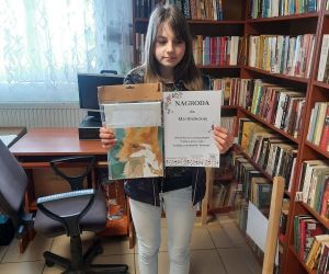 Nastolatka prezentuje dyplom i nagrodę zdobytą w konkursie