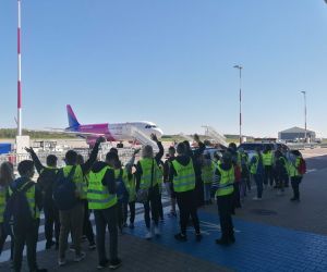 Uczniowie przed Portem Lotniczym witający lądujący statek powietrzny