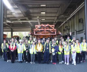 Uczniowie wraz z opiekunami przed budynkiem straży pożarnej , w którym znajduje się sprzęt do odśnieżania lotniska