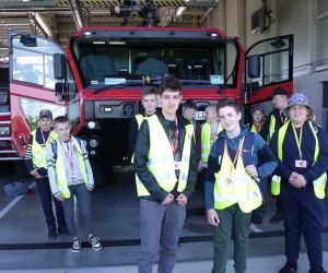 Uczniowie  przed budynkiem straży pożarnej, w którym znajduje się nowoczesny sprzęt do gaszenia pożarów na wypadek awarii statków powietrznych