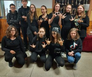 Klasa ósma w czarnych strojach na korytarzu szkolnym