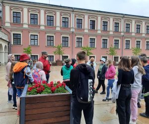 Uczniowie z przewodnikiem znajdują się na dziedzińcu zamkowym