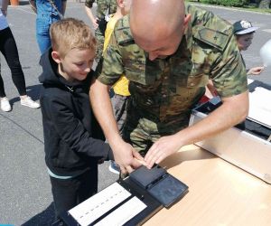 Uczeń z pracownikiem Straży Granicznej podczas zdejmowania odcisków palców.