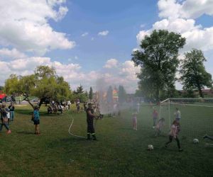 Strażak prezentuje działanie węża pożarniczego.