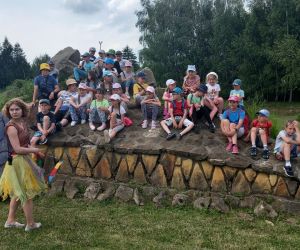 Uczniowie siedzący na kamiennej głowie smoka