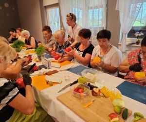 Grupa osób podczas warsztatów, wewnątrz budynku.