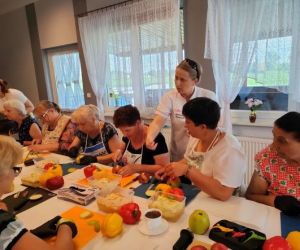 Grupa osób podczas warsztatów, wewnątrz budynku.