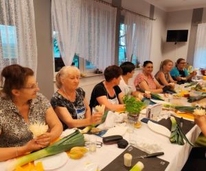 Grupa osób podczas warsztatów, wewnątrz budynku.