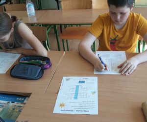 Uczniowie rozwiązują krzyżówkę i zadania związane z tematyką bezpiecznych wakacji