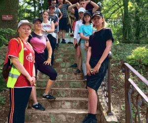 Grupa osób stoi na schodach.