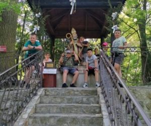 Uczniowie siedzą lub stoją przed figurką św. Mikołaja w Kryłowie