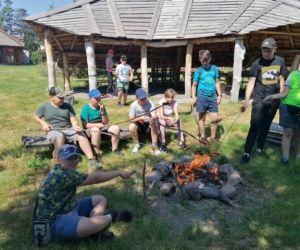 Uczniowie pieką kiełbaski w ognisku