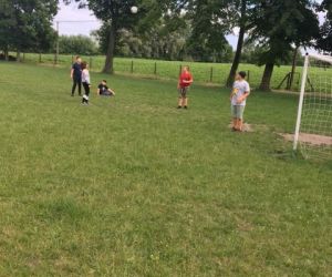 Uczniowie grają w piłkę na boisku szkolnym