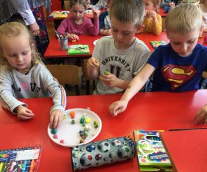 Dzieci nawlekają koraliki.