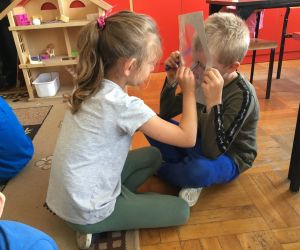 Dziecko rysuje portret kolegi na folii