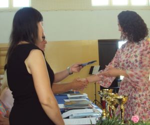 Dyrektor wręcza list gratulacyjny kobiecie – rodzic uczennicy klasy ósmej