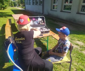 Animatorka maluje buzię chłopcu