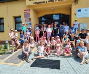 Grupa osób przed budynkiem.