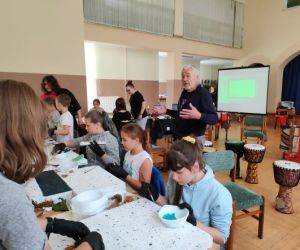 Grupa osób podczas warsztatów plastycznych.