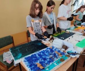 Grupa osób podczas warsztatów plastycznych.