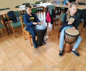 Osoby grają na bębnach.