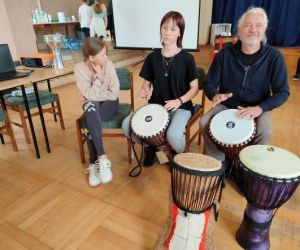 Osoby grają na bębnach.