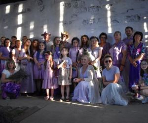 Grupa osób w lawendowych strojach.