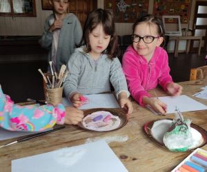 Zdjęcie przedstawia dzieci wykonujące prace kolorową solą.