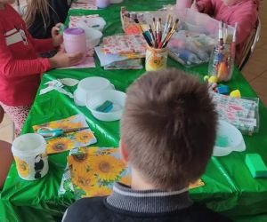 Zdjęcie przedstawia dzieci wykonujące pracę plastyczną metodą dekupage.