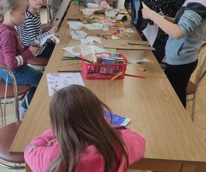 Zdjęcie przedstawia dzieci wykonujące prace plastyczne z papieru.