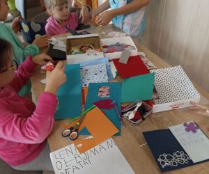 Zdjęcie przedstawia dzieci wykonujące kartki okolicznościowe.