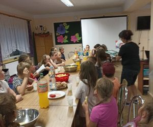 Na zdjęciu znajduje się grupa dzieci w trackie poczęstunku.