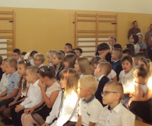 Grupa uczniów w strojach galowych.