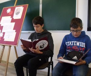 Dwóch uczniów klasy ósmej czytających teksty ballad Mickiewicza