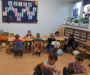 Przedszkolaki siedzą przy stolikach