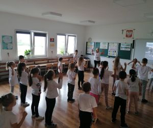 Uczniowie klas młodszych ćwiczą z nauczycielką