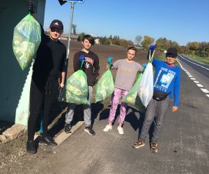 Uczniowie klasy VIII z workami śmieci z przystanku autobusowego
