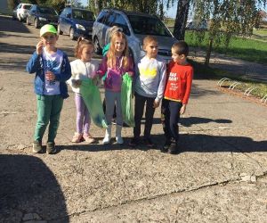 Uczniowie klasy II z workami śmieci zebranymi na terenie wokół szkoły