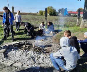 Uczniowie pieką jabłka nad ogniskiem