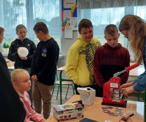 Uczniowie przyglądają się tworzeniu imiennych pamiątkowych przypinek