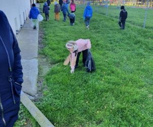 uczniowie do odpowiedniego worka zbierają śmieci.